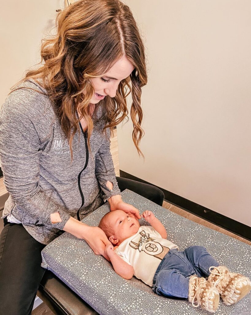 Dr. Lara a pediatric chiropractor working with an infant. 