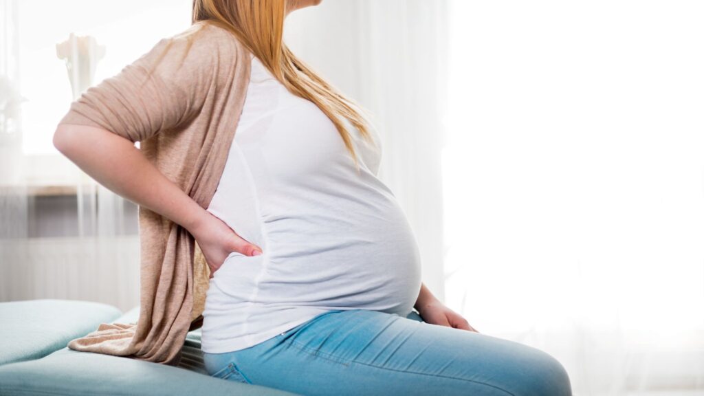 A pregnant woman dealing with back pain from her pregnancy. 