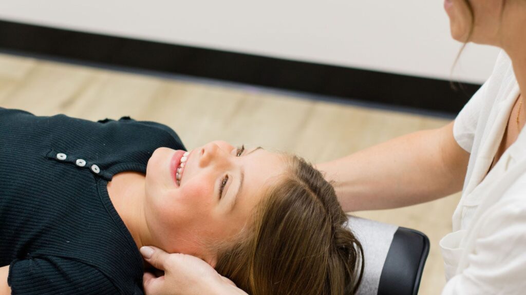 A pediatric chiropractor working with a patient at Impact Chiropractic. 