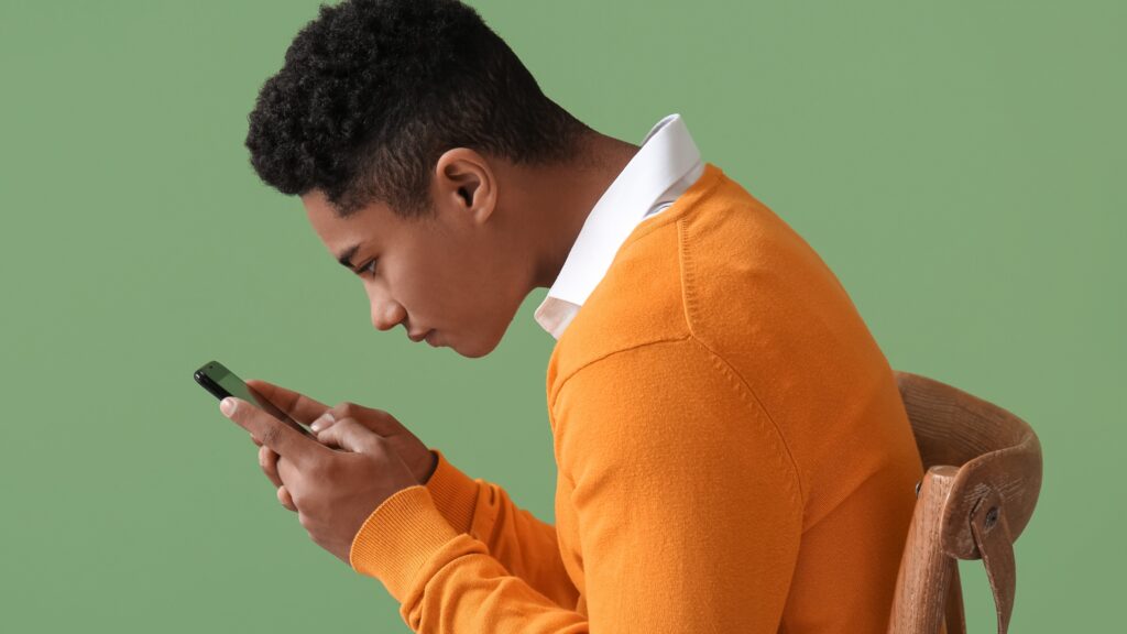 a teenager with bad posture looking at his phone