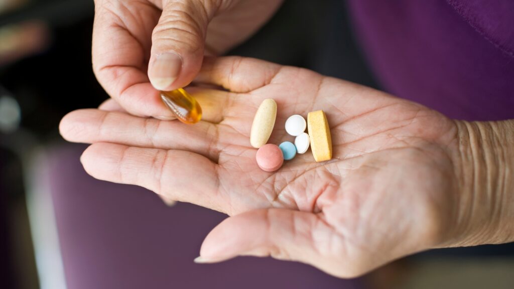 a woman holding some medications or vitamins